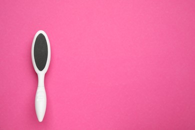 Photo of White foot file on pink background, top view with space for text. Pedicure tool