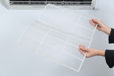 Photo of Woman holding air conditioner filters indoors, closeup