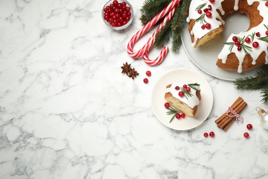 Flat lay composition with traditional homemade Christmas cake on white marble table, space for text
