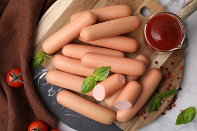 Photo of Delicious boiled sausages with spices, sauce and tomatoes on table, flat lay