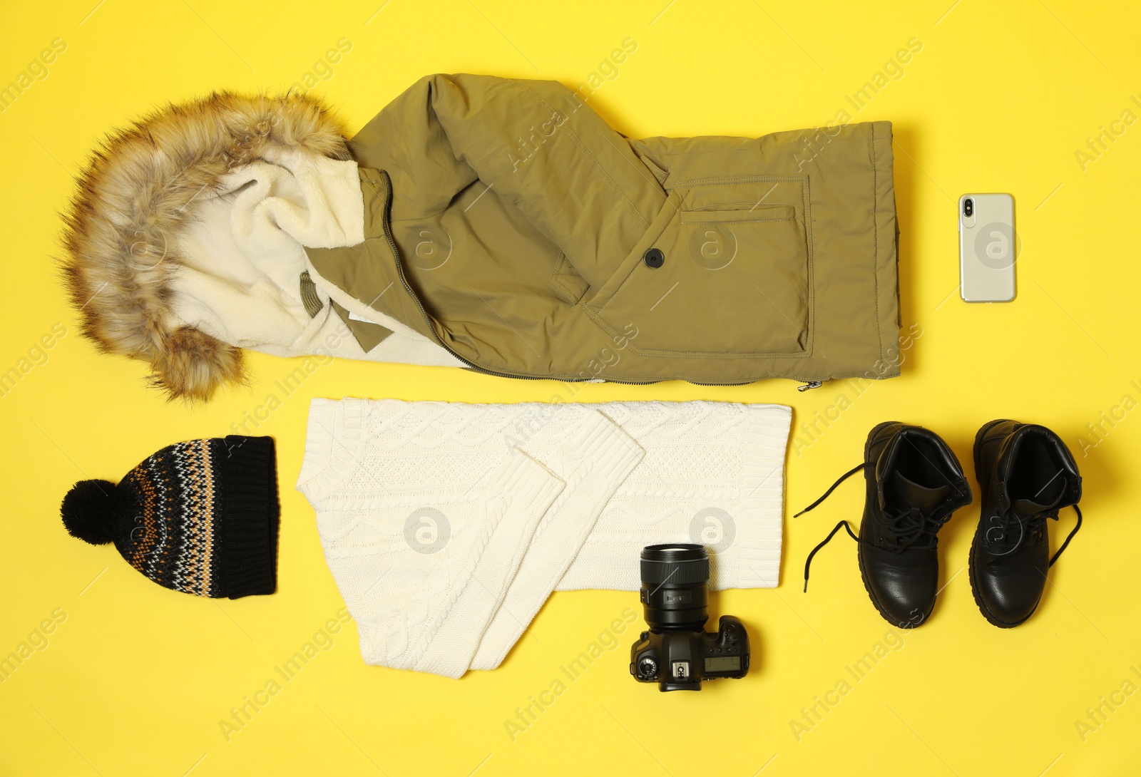 Photo of Flat lay composition with warm female clothes for winter vacation on color background