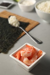 Photo of Shrimps in bowl for sushi on grey textured table, closeup