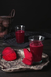 Photo of Plate with glass of beet smoothie on table