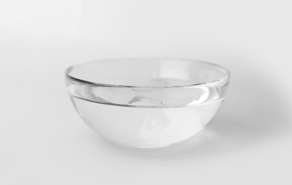 Photo of Glass bowl full of water on white background