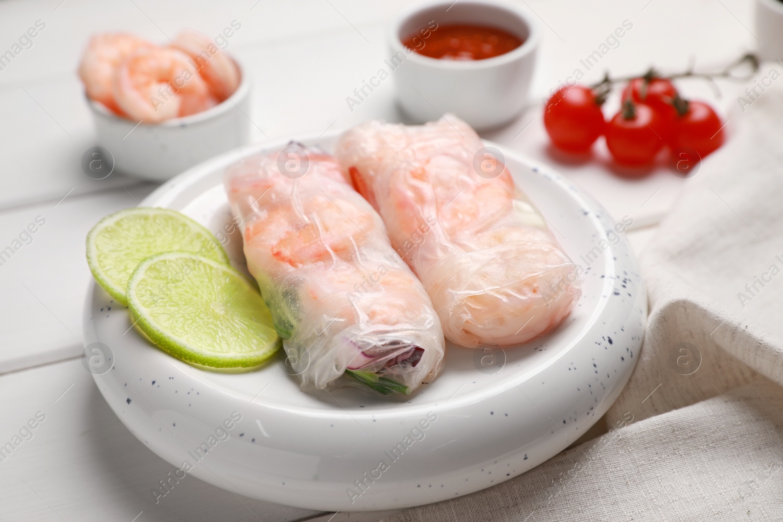 Photo of Delicious spring rolls with shrimps wrapped in rice paper on white wooden table, closeup