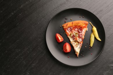 Plate with delicious pizza Diablo, pepper, tomato and peppercorns on dark textured table, top view. Space for text