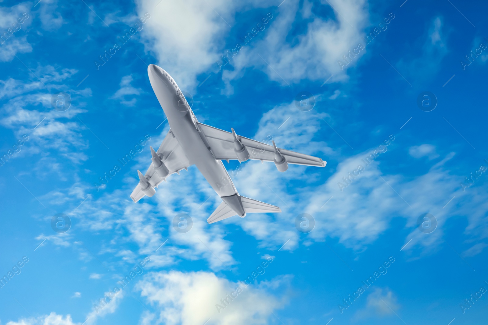 Image of Airplane flying in blue sky with clouds. Air transportation