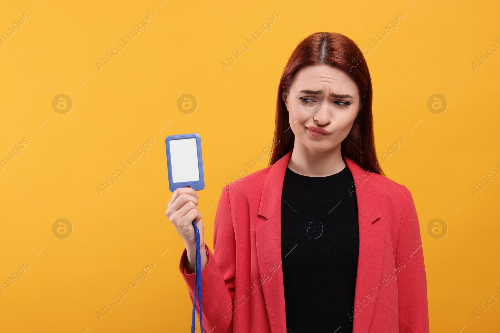 Photo of Disappointed woman with vip pass badge on orange background, space for text