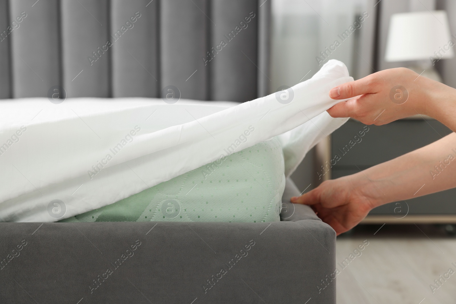 Photo of Maid making bed in hotel room, closeup. Space for text