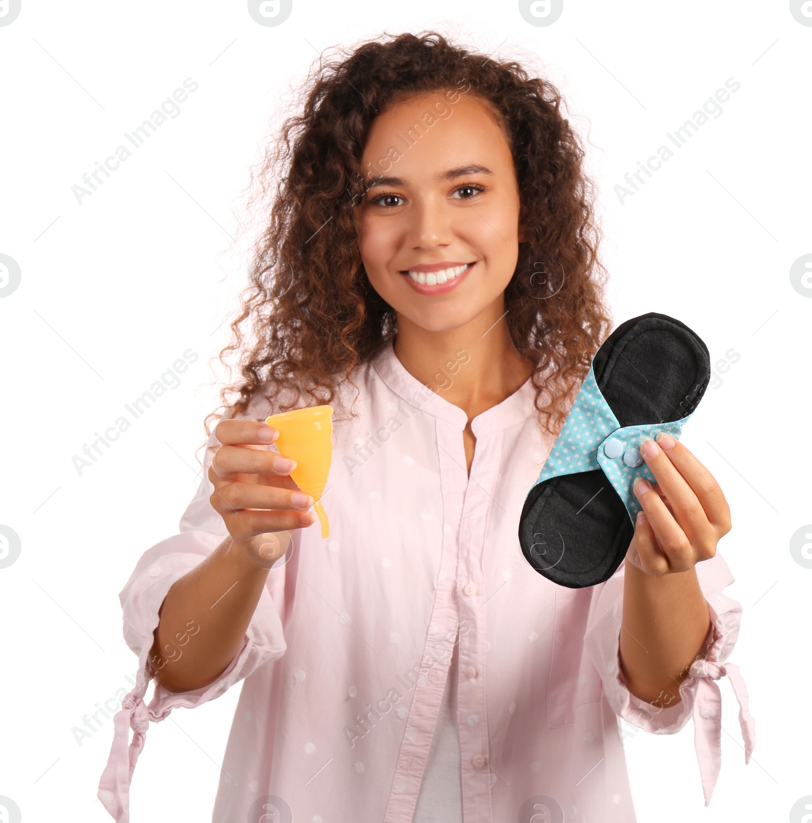 Photo of Young African American woman with reusable pad and menstrual cup on white background