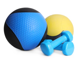 Photo of Medicine balls with dumbbells on white background