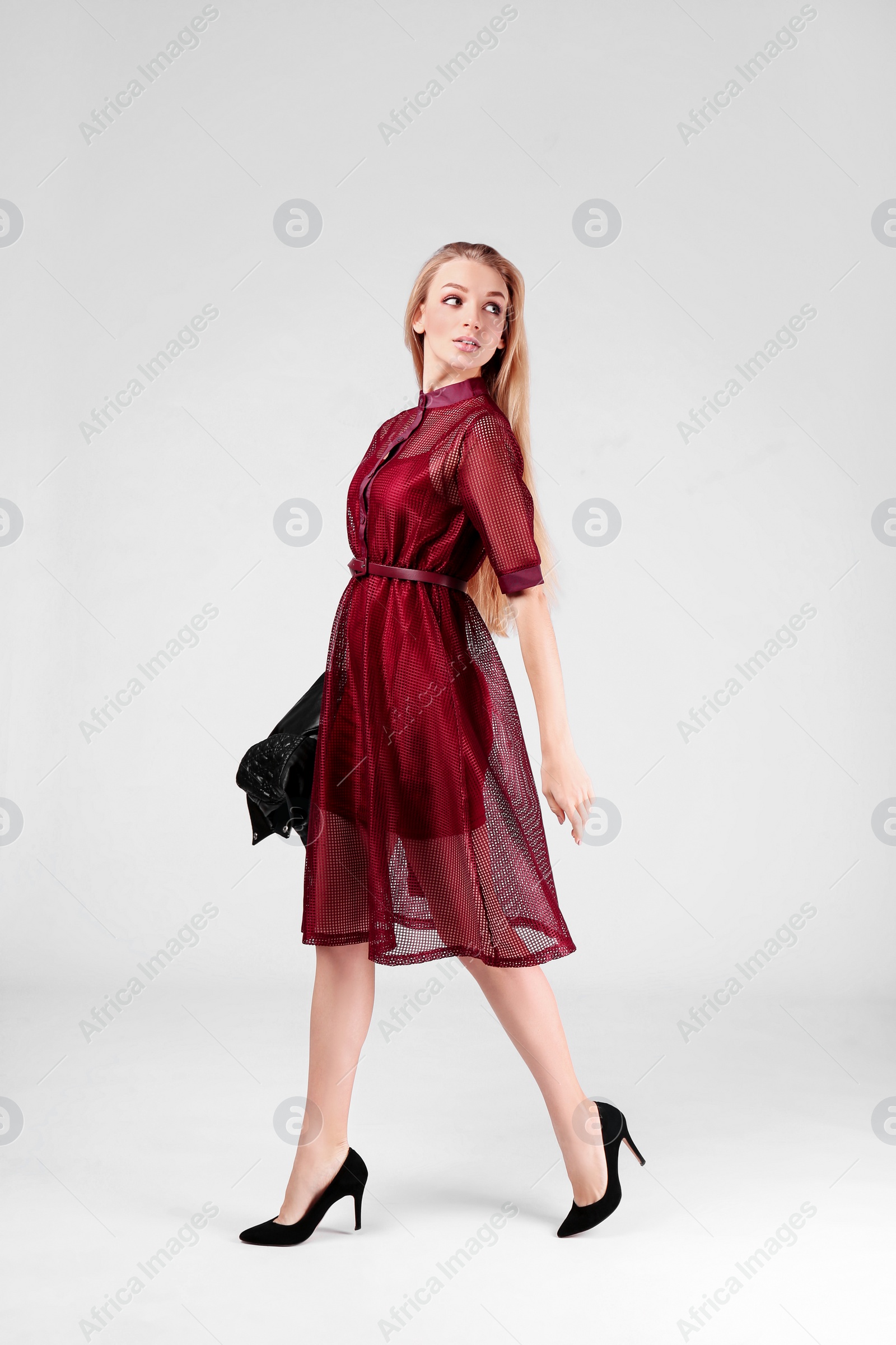 Photo of Young stylish woman in trendy shoes on light background