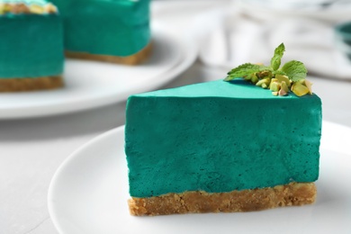 Photo of Delicious homemade spirulina cheesecake served on light table