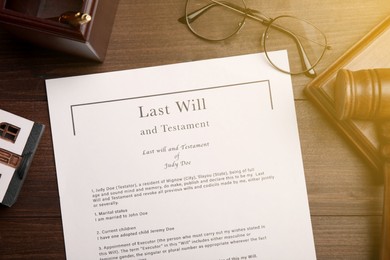 Image of Last Will and Testament, glasses and gavel on wooden table, flat lay