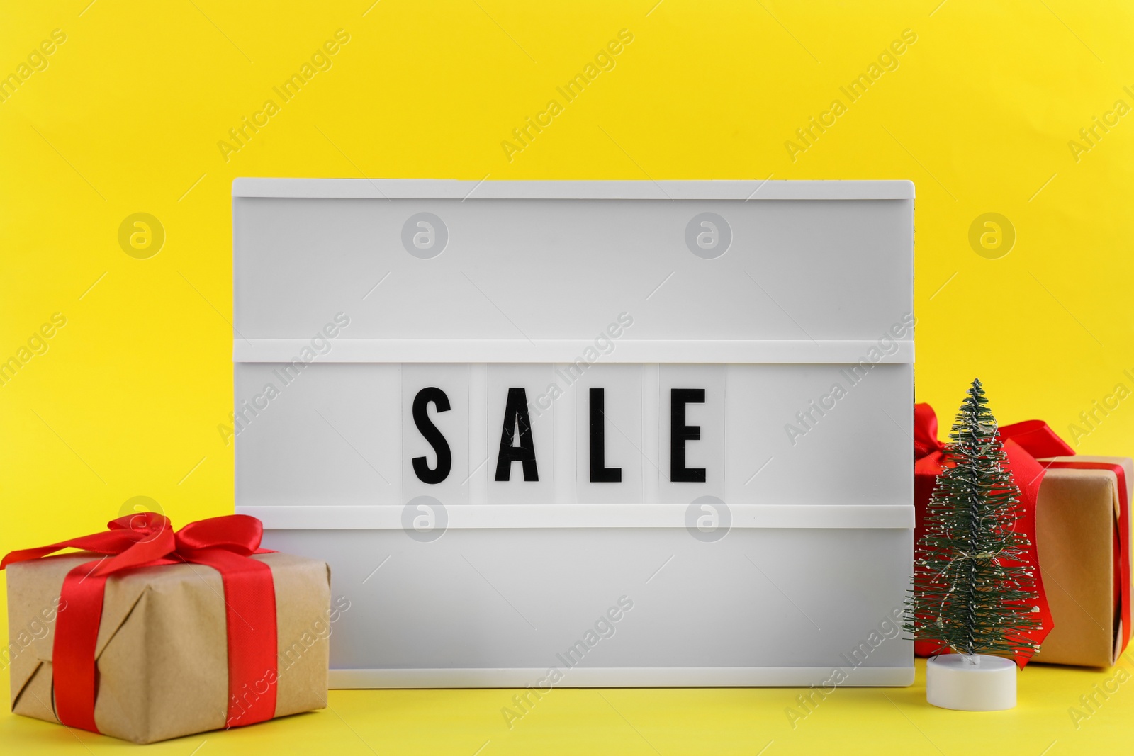 Photo of Lightbox with word Sale and Christmas decor on yellow background