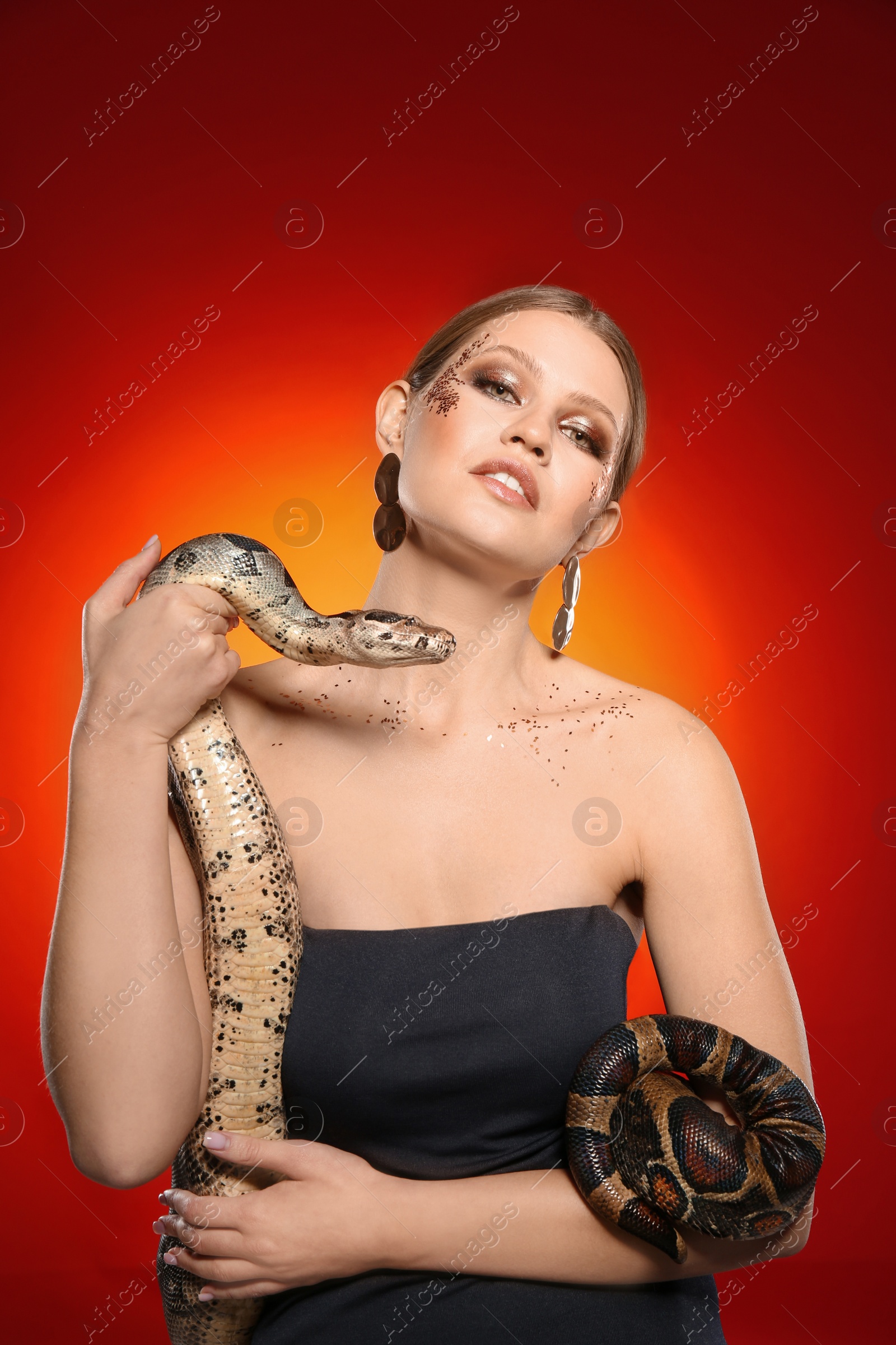 Photo of Beautiful woman with boa constrictor on bright colorful  background