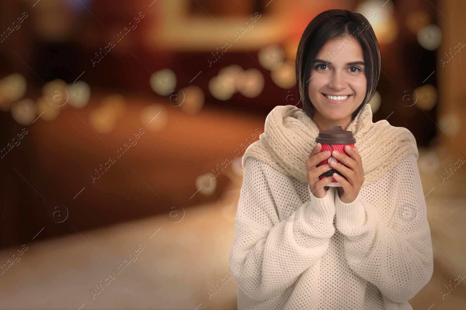 Image of Happy beautiful woman with paper cup of mulled wine outdoors