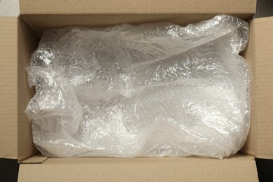 Photo of One open cardboard box with bubble wrap, top view