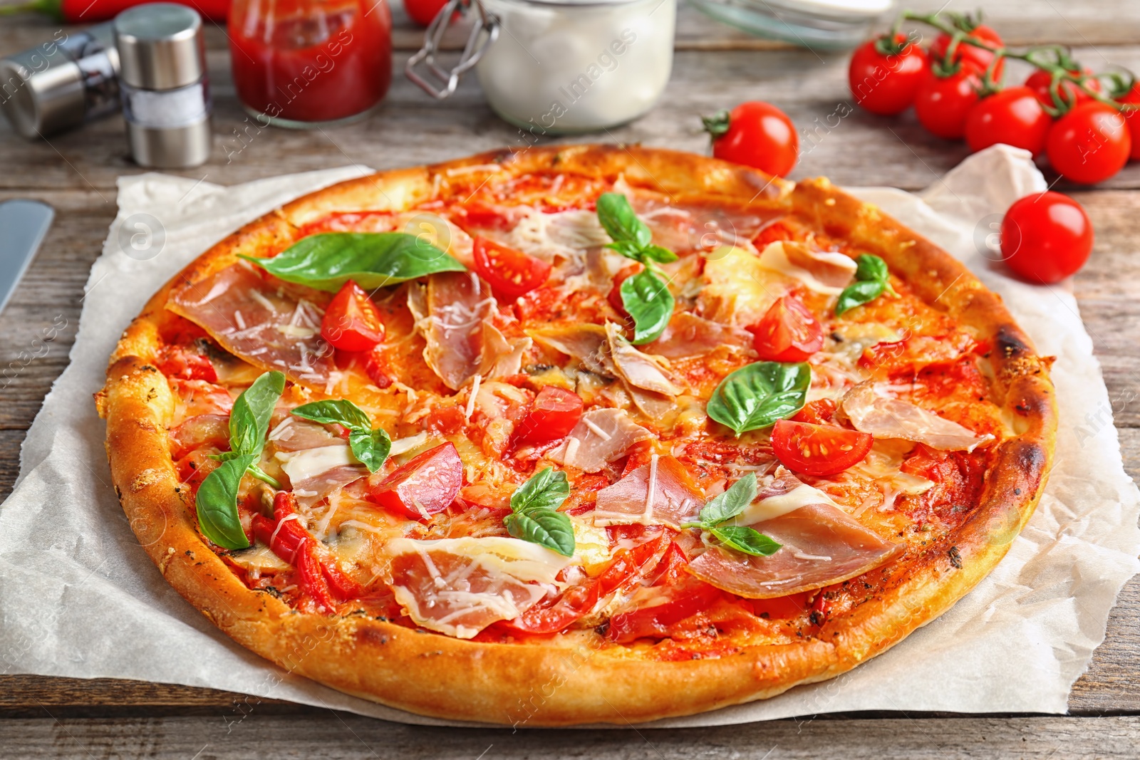 Photo of Delicious pizza with tomatoes and meat on table