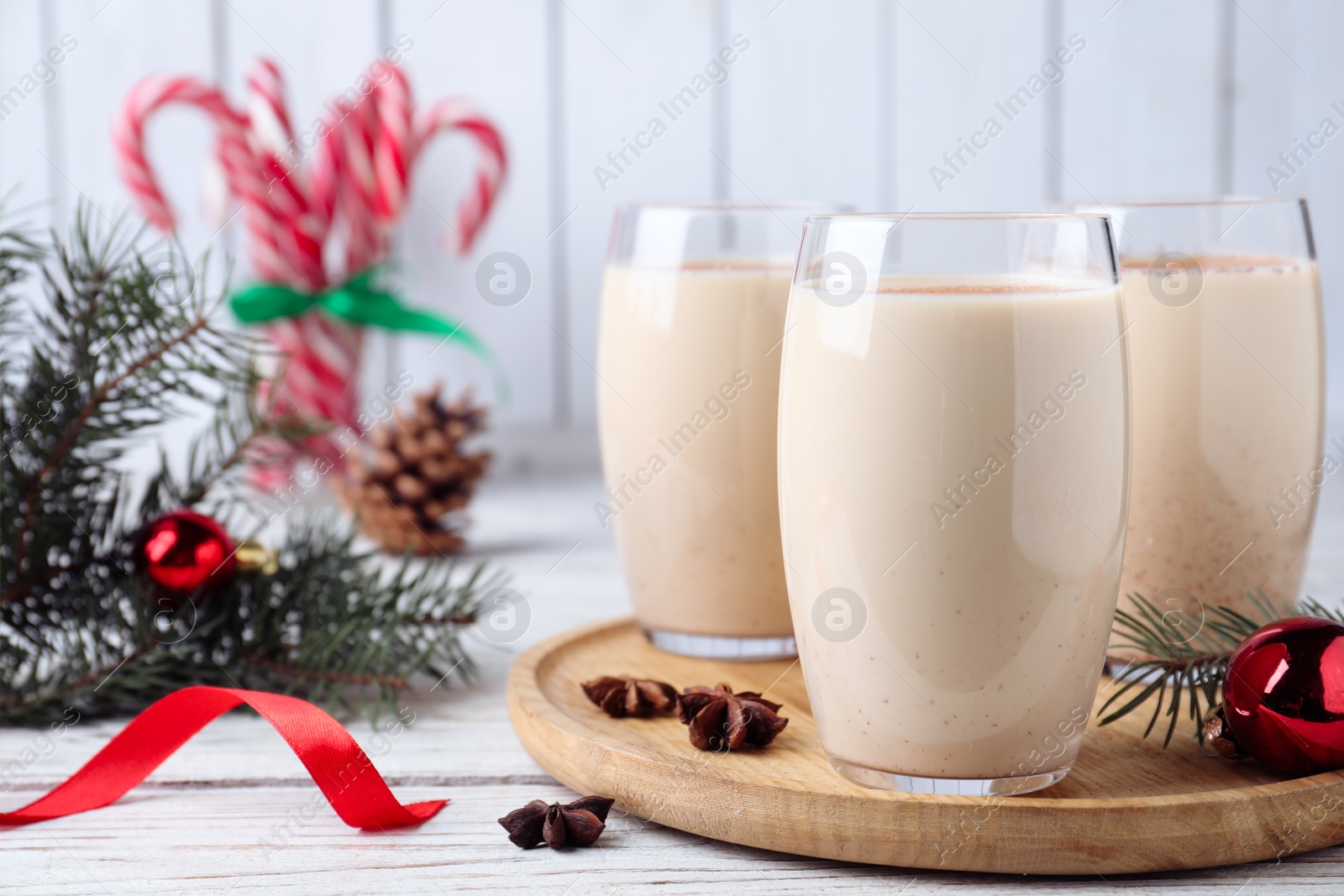 Photo of Delicious Christmas cocktail with liqueur on white wooden table. Space for text