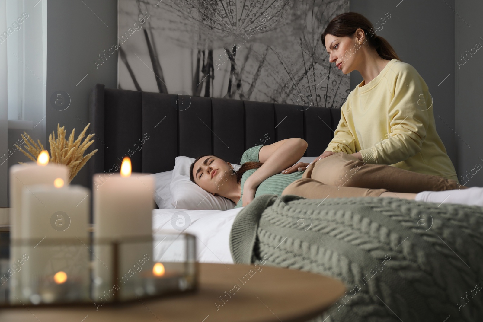 Photo of Doula taking care of pregnant woman in bedroom. Preparation for child birth