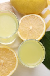 Tasty limoncello liqueur and lemons on table, top view