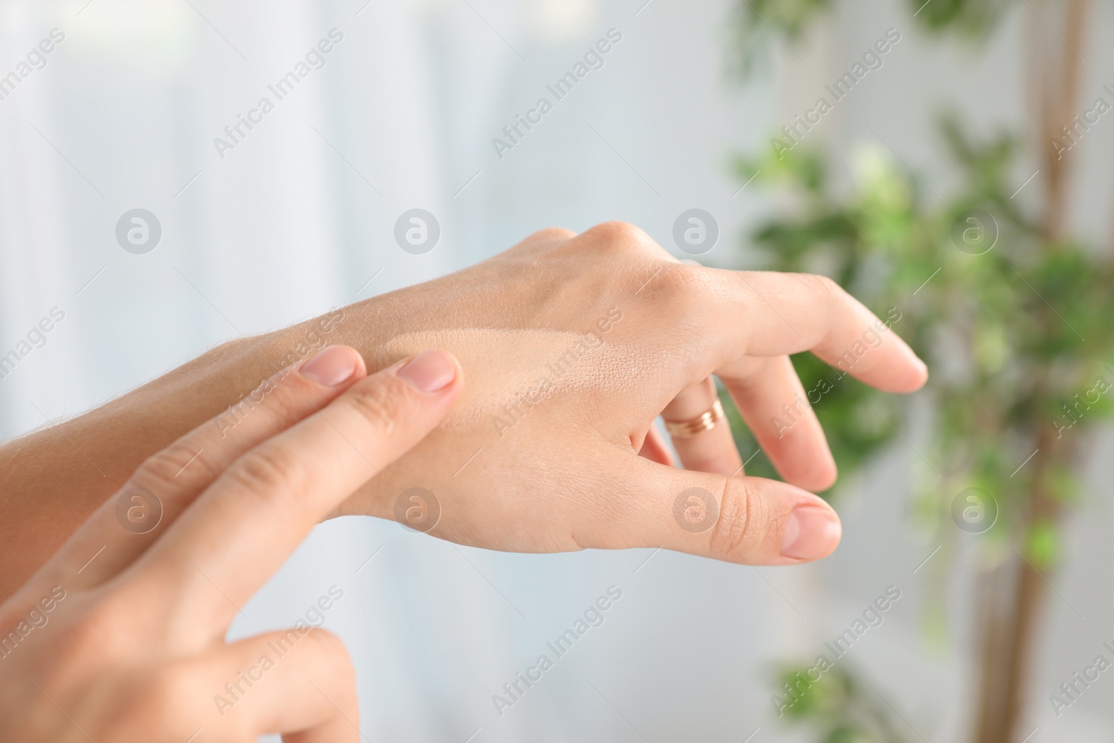 Photo of Woman testing foundation tone on hand, closeup