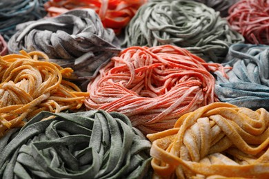 Rolled pasta painted with food colorings as background, closeup