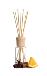New reed air freshener, anis, cinnamon sticks and slice of orange on white background