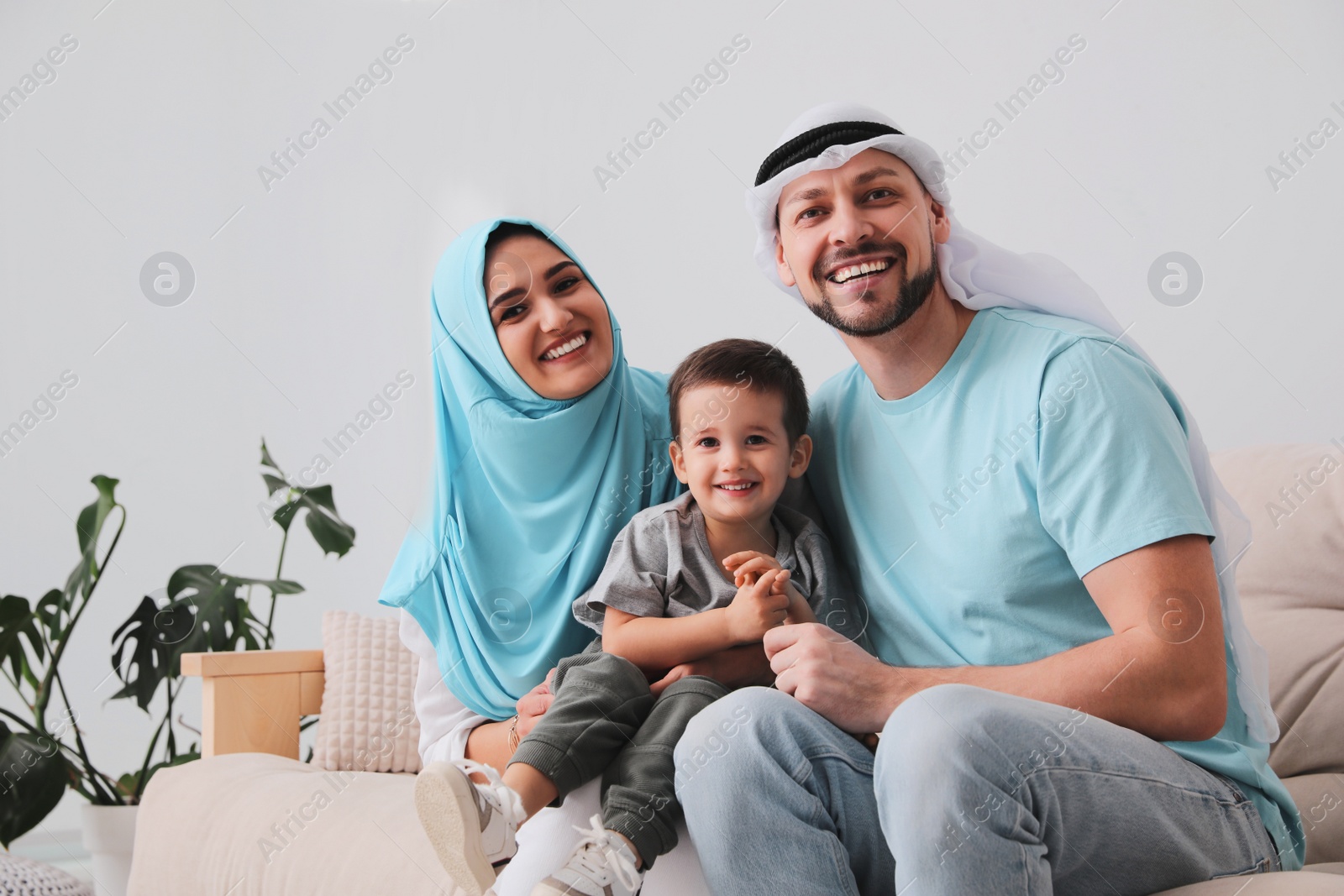 Photo of Happy Muslim family on sofa in living room