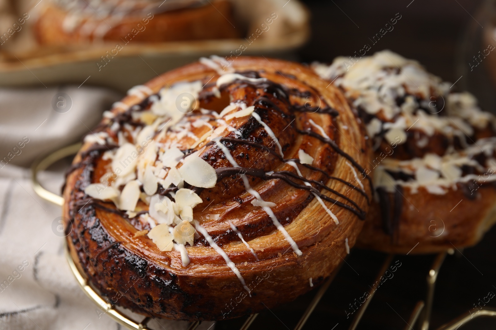 Photo of Delicious rolls with toppings and almond on table, closeup. Sweet buns