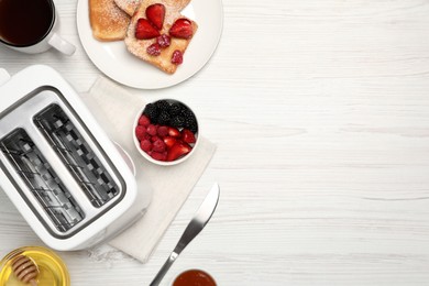 Flat lay composition with modern toaster on white wooden table. Space for text