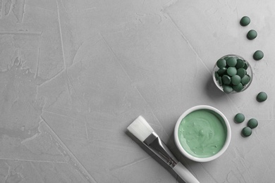 Photo of Flat lay composition with freshly made spirulina facial mask on light grey table. Space for text