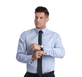 Photo of Handsome stylish man putting on cufflink against white background