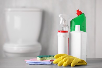 Different cleaning supplies on table indoors, space for text