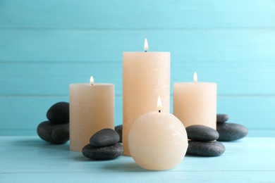 Composition of burning candles and spa stones on table