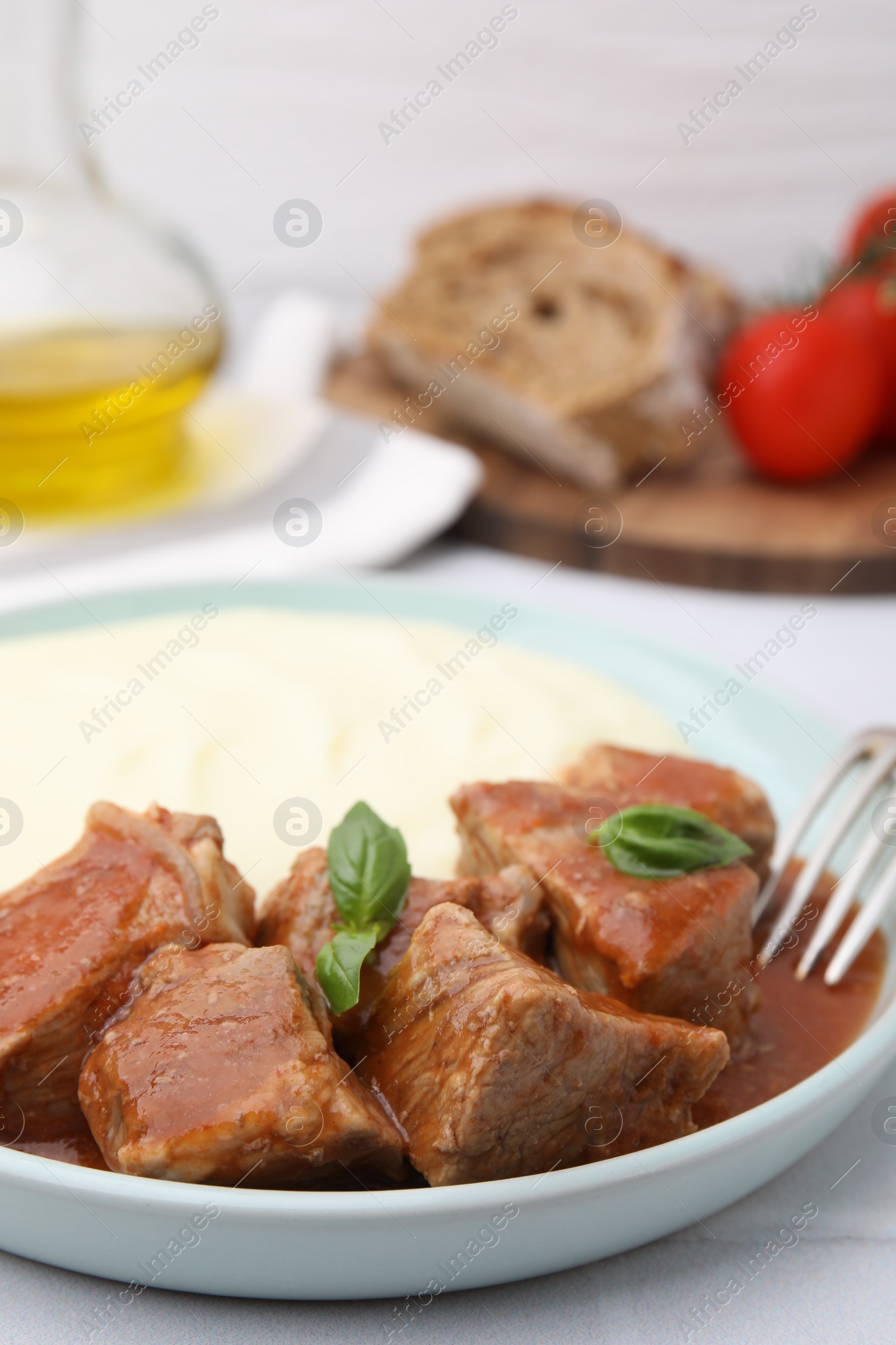 Photo of Delicious goulash served with mashed potato on table, closeup