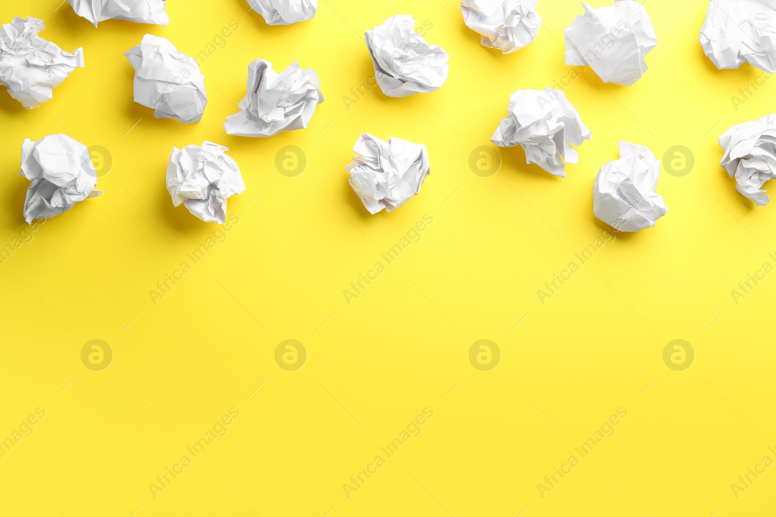 Photo of Crumpled sheets of paper on yellow background, flat lay. Space for text