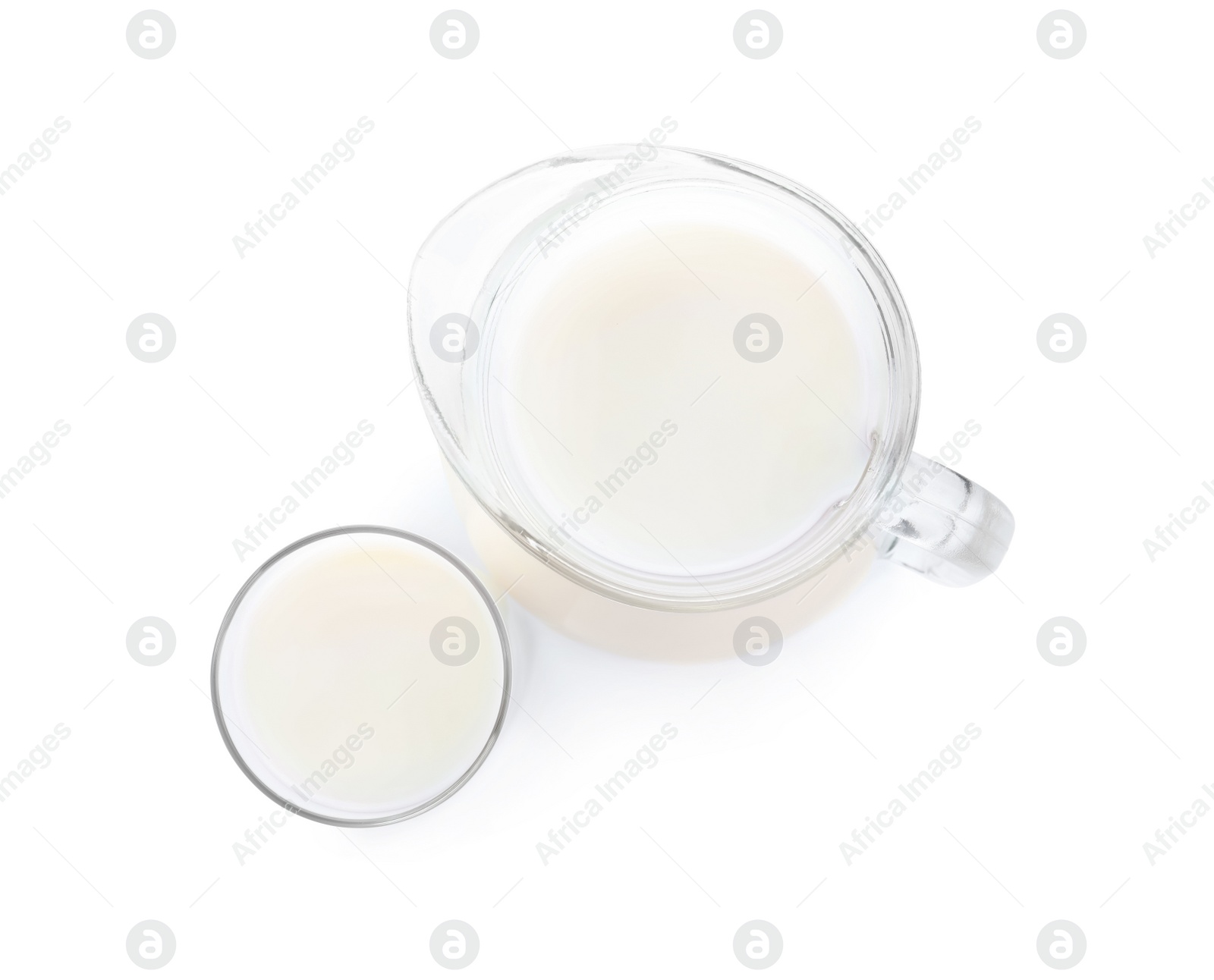 Photo of Jug and glass with fresh milk on white background, top view