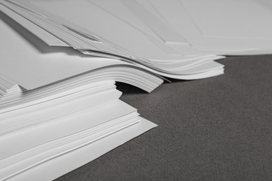 Pile of paper sheets on grey background, closeup. Space for text