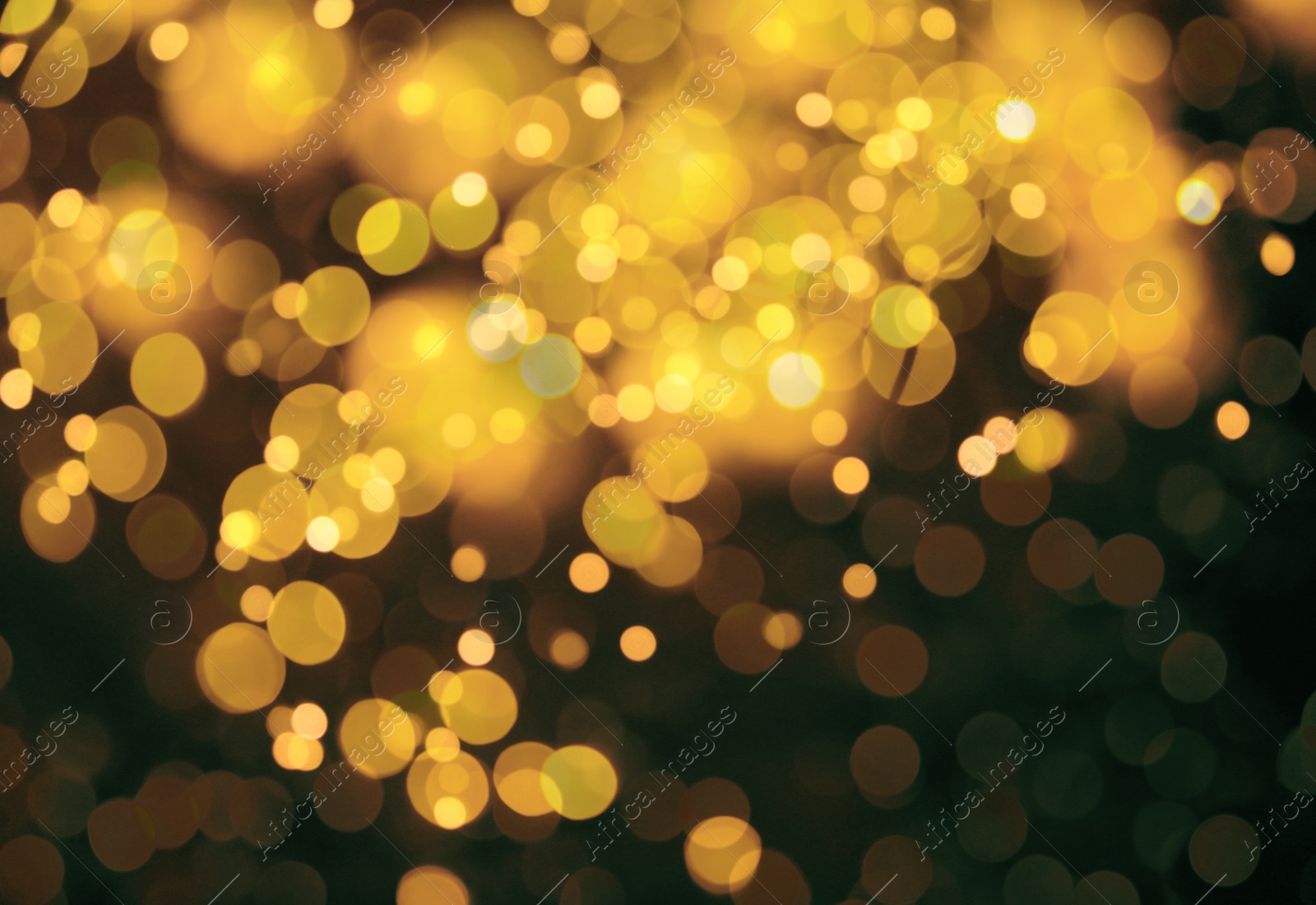 Image of Blurred view of gold lights on dark background, bokeh effect