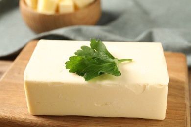 Photo of Tasty butter with parsley on wooden table, closeup