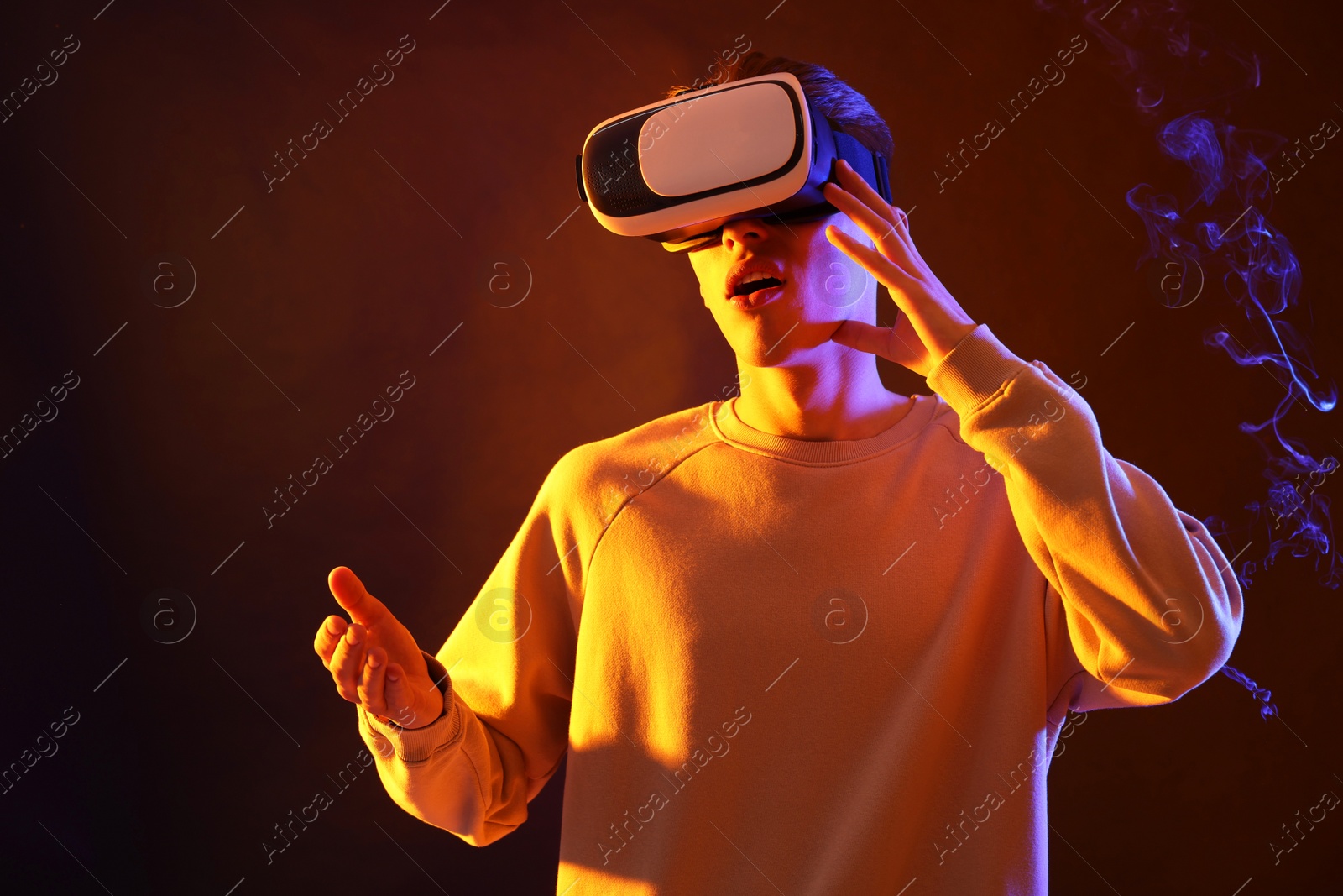 Photo of Young man with virtual reality headset on brown background