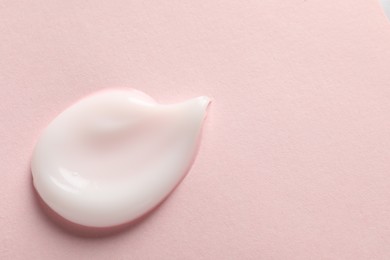 Sample of face cream on pink background, top view. Space for text