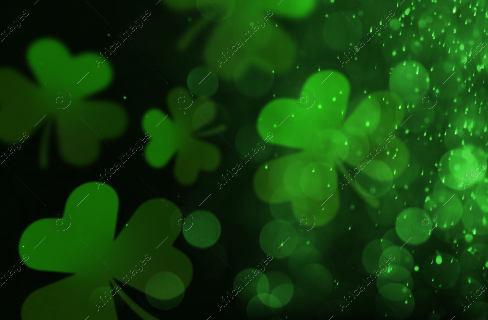 Image of St. Patrick's Day celebration. Clover leaves on black background, bokeh effect