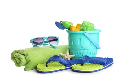 Photo of Set of plastic beach toys, towel, sunglasses and flippers on white background