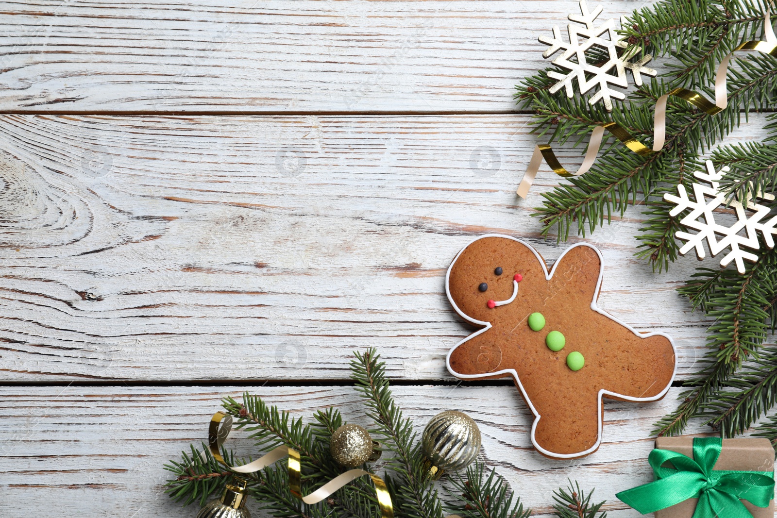 Photo of Flat lay composition with gingerbread man on white wooden table, space for text