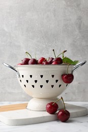 Photo of Fresh ripe cherries with water drops on white marble table