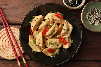 Photo of Delicious gyoza (asian dumplings) served on wooden table, flat lay