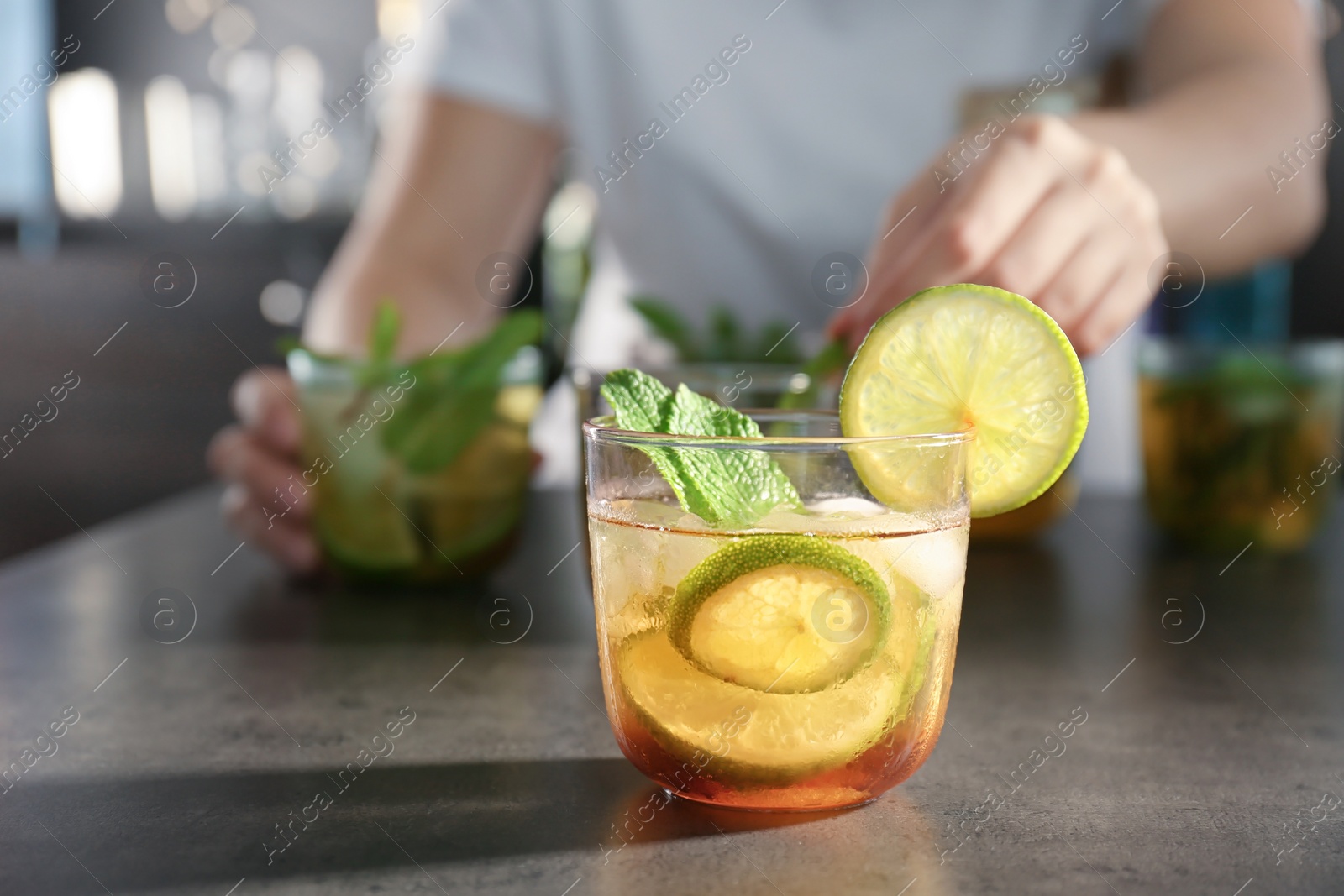 Photo of Glass with delicious mint julep cocktail and blurred person on background